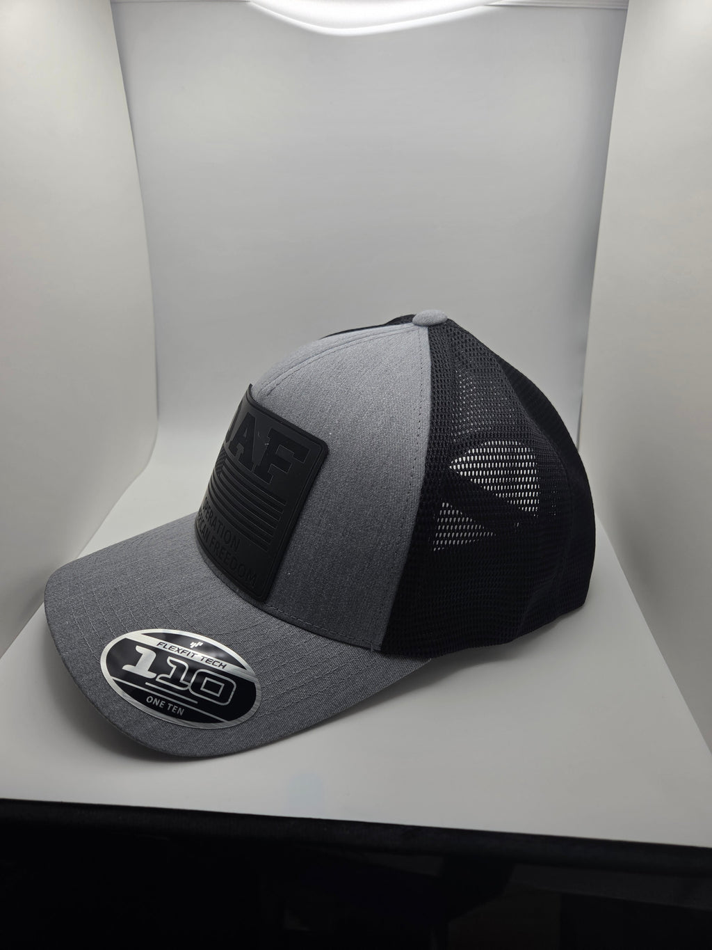 OAF Operation American Freedom black patch on a gray and black Flexfit 110 hat
