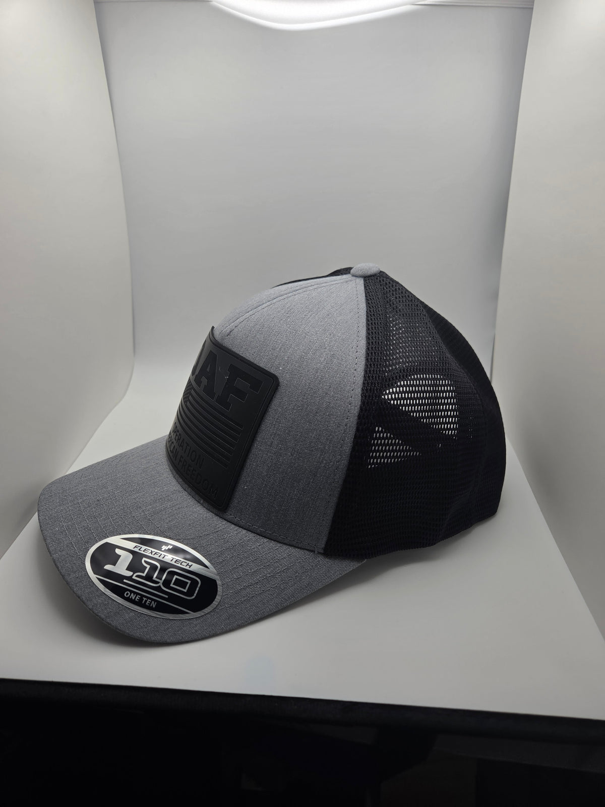 OAF Operation American Freedom black patch on a gray and black Flexfit 110 hat