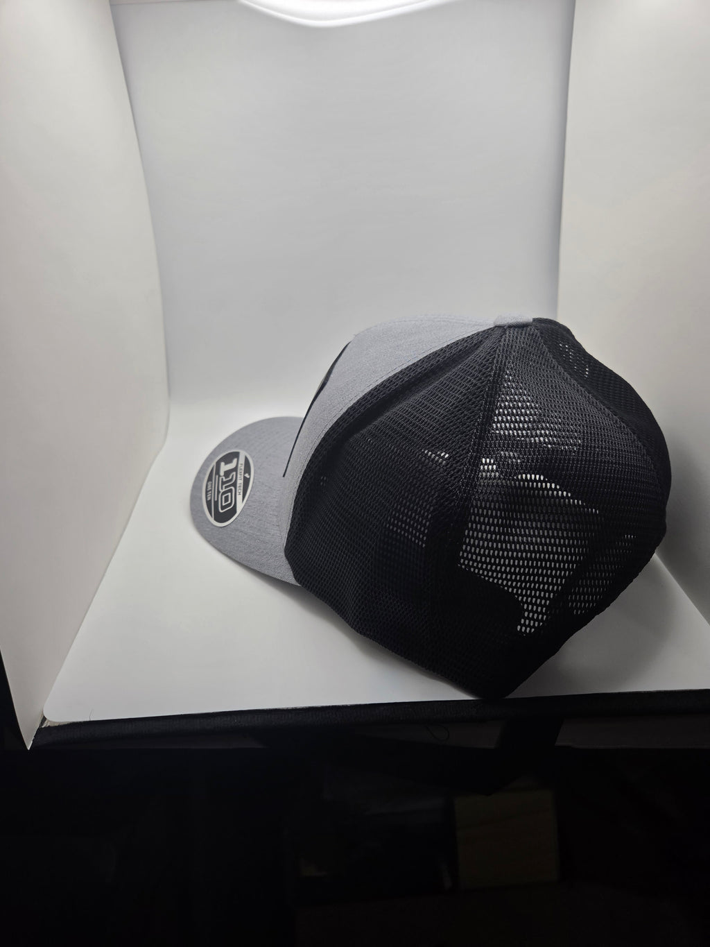 Rear three-quarter view of the gray and black mesh Flexfit 110 hat